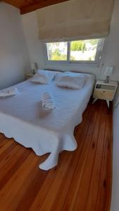 un grande letto bianco in una stanza con finestra di Dpto en Tandil a Tandil