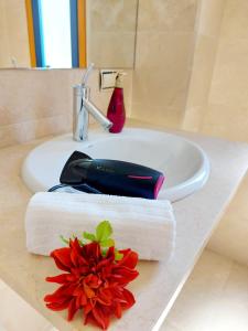 a bathroom sink with a red flower on a towel at Duplex with sea views, garden and terrace in Santa Cruz de Tenerife