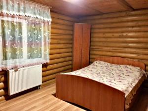 um quarto com uma cama e uma janela em Сонячні Карпати2 em Slavske