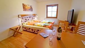 Habitación con cama y mesa con botella de vino en Vila Edith Valtice, en Valtice