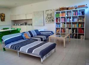 a living room with two couches and a book shelf at Villa Nannia Beautiful Roccamare Private Beach in Castiglione della Pescaia