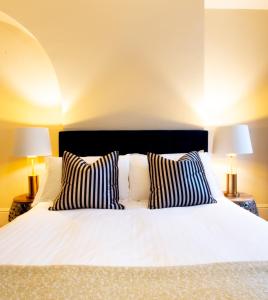 um quarto com uma cama branca e 2 candeeiros em Salisbury Residence by Charles Hope em Salisbury