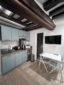 a kitchen with white cabinets and a white table at Les Maisons d'Augustine, nouvelle demeure de la cour Ste Catherine in Honfleur