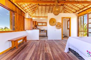 a bedroom in a villa with a bed and a kitchen at Bangalô do Vento - Praia do Preá in Prea