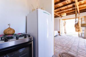 a kitchen with a refrigerator and a stove at Bangalô do Vento - Praia do Preá in Prea