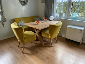 a dining room table with yellow chairs and a table at Ferienwohnung "kleine Auszeit" in Olsberg +9 photos