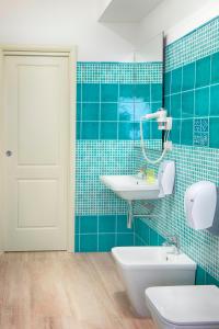 Domo LA VELA في سانت أونتيوكو: حمام من البلاط الأزرق مع حوض ومرحاض