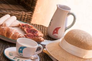 a table with a plate of bread and a cup of coffee at Domo La Vela - Affittacamere - Living Sant'Antioco in SantʼAntìoco