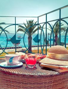 uma mesa de vime com um chapéu, uma chávena de café e uma bebida em Domo LA VELA em SantʼAntìoco