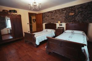 a bedroom with two beds and a brick wall at Apartamentos Rurales Los Galpones in Coaña