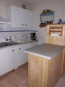 a kitchen with white cabinets and a counter top at T2 Résidence de l'Ars Aulus les Bains in Aulus-les-Bains