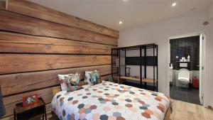 1 dormitorio con una pared de madera y 1 cama en Apartment Chez Esmara et Philippe, en Bruselas