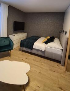 a bedroom with a bed and a table and a tv at Apartmán Hestia 5 in Rajecké Teplice