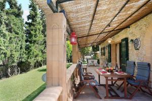 un patio con mesa y sillas bajo toldo en Sunset Villa Es Pujolet, en Alcudia