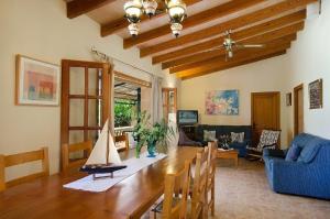 una sala de estar con una mesa de madera y un velero. en Sunset Villa Es Pujolet, en Alcudia