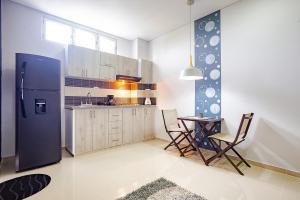 uma cozinha com um frigorífico, uma mesa e cadeiras em Ayenda Montepinares em Montería