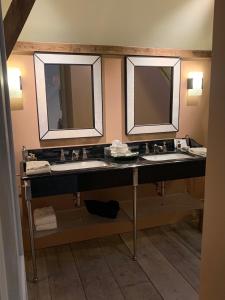 two sinks in a bathroom with two mirrors at B&B The Verhaegen in Ghent