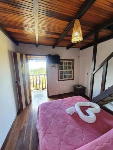 a bedroom with a large pink bed in a room at Pousada Bem Querer in Lavras Novas