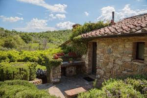an external view of a stone house with a garden at Le Logge in Pergine Valdarno