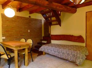 a bedroom with a bed and a table with chairs at Cabaña Cafuné in El Bolsón