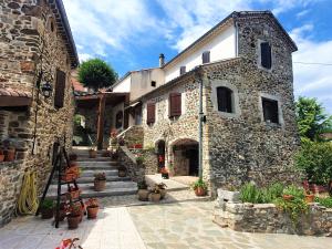 a stone building with stairs and potted plants at Mes Maisons - Two Gites with Private and Shared pools in Cévennes in Gagnières