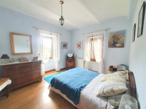 a bedroom with a bed and a dresser and windows at Mes Maisons - Two Gites with Private and Shared pools in Cévennes in Gagnières