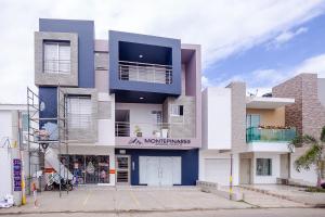 un edificio azul y blanco con un cartel en él en Ayenda Montepinares, en Montería