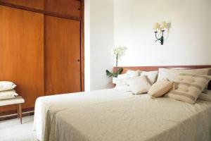 a bedroom with a large white bed with a wooden headboard at Apartment Sant Antoni de Calonge in Sant Antoni de Calonge