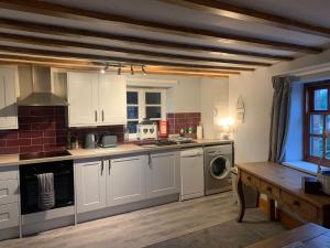 a kitchen with white cabinets and a stove top oven at Apartment Two, The Carriage House, Bilbrough, York in York