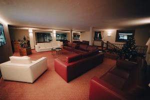 a living room with red and white furniture and a christmas tree at Hotel Renzi in Folgarida