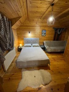 een slaapkamer met een bed in een houten kamer bij Girske Povitria Cottage in Jaremtsje