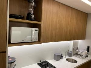 a kitchen with a microwave and a sink at ECO RESORT PRAIA DOS CARNEIROS in Tamandaré