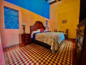 um quarto com uma cama e um piso em xadrez em Catrina & Diego em Mérida