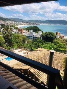 a view of the ocean from the balcony of a house at Pousada Palmeiras in Bombinhas