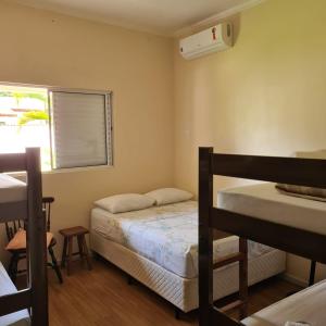 um quarto com 2 beliches e uma janela em Taipas Pousada e Camping em Iporanga