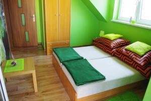 a green room with two beds and a table at Nad Biebrzą Wojciech Bielawski in Goniadz
