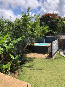 un patio trasero con piscina y plantas en Aruã Suítes & Café, en Penha