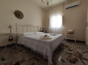 een slaapkamer met een bed met een witte sprei en een raam bij Residenza "I Tre Carrubi " in Fasano