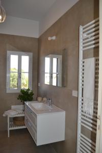 een badkamer met een wastafel en een spiegel bij Residenza "I Tre Carrubi " in Fasano