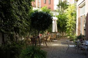 patio ze stołami, krzesłami i parasolem w obiekcie Residencia Alclausell w mieście Tarragona