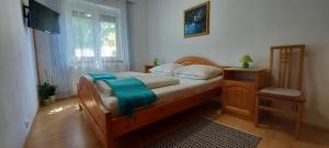 ein Schlafzimmer mit einem Bett mit einer blauen Decke darauf in der Unterkunft Violetta Vendégház in Keszthely