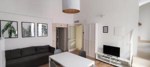 - un salon avec un canapé et une télévision dans l'établissement Appartamenti Mascagni, à Sannicandro di Bari