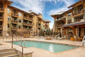 an apartment complex with a swimming pool in a courtyard at Luxury Resort Ski In Ski Out Hyatt Centric Residence 1BR Condo Pool Gym Hot tub Restaurant More in Park City