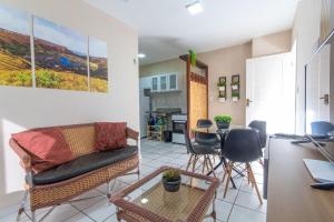 sala de estar con sofá, sillas y mesa en Apartamento Climatizado em Natal por Carpediem, en Natal