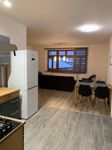 eine Küche mit einem weißen Kühlschrank und einem Tisch mit Stühlen in der Unterkunft Apartmán na náměstí in Králíky