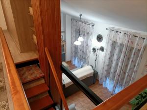 Habitación con cama y escalera con cortinas. en Apartamento Rosa de Alejandría, en Olivenza