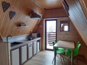 una cocina con mesa y algunas sillas verdes en Willa u Kasi en Zakopane