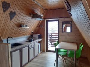 una cocina con mesa y algunas sillas verdes en Willa u Kasi, en Zakopane