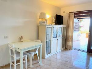 a dining room with a table and a tv at Casa Leo - Villaggio Baia De Bahas in Golfo Aranci