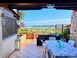a table on a patio with a view of the ocean at Casa Leo - Villaggio Baia De Bahas in Golfo Aranci